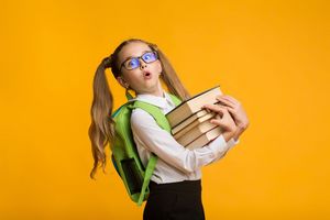 Shocked Nerdy Schoolgirl Carrying Heavy Books On Yellow Background